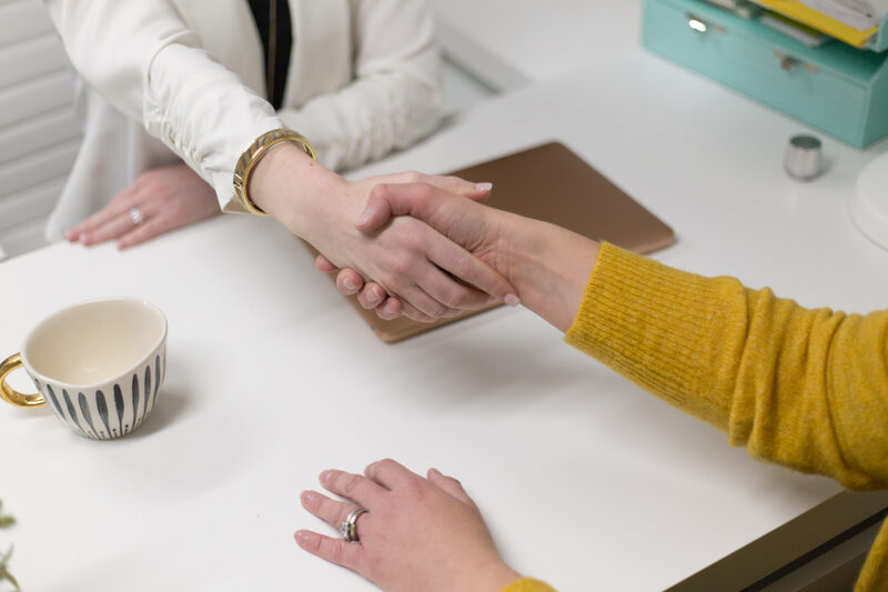Two business professionals shaking hands after closing a new customer agreement