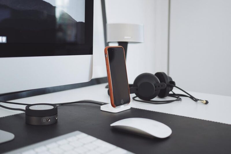 Modern office desk with a business phone dock and headset for VoIP calling
